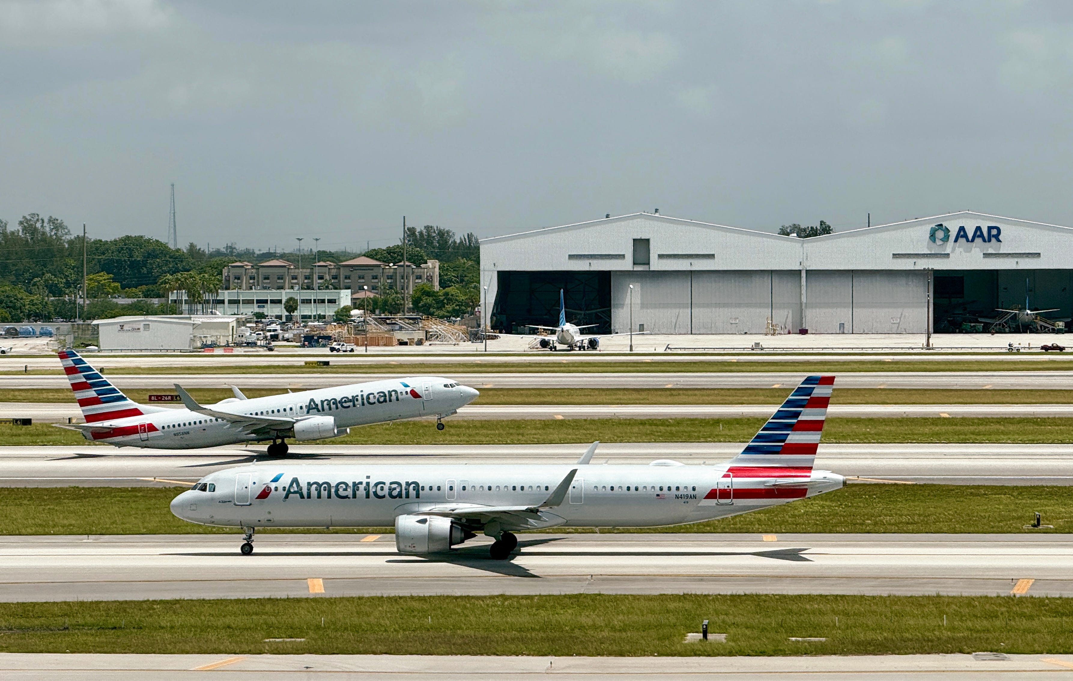 An American Airlines plane takes off as another taxis to the runway at Miami International AirPort (MIA)