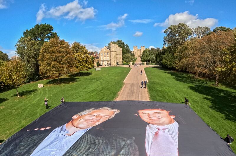 TOPSHOT - A handout image from the UK collective 'Everyone Hates Elon' shows activists unfurling a large photo depicting US President Donald Trump posing with Jeffrey Epstein, on the Long Walk, outside Windsor Castle in Windsor, on September 15, 2025, ahead of a State visit by the US president. Donald Trump lands in Britain on Tuesday for an historic second state visit that will see the UK government spare no effort in trying to flatter the mercurial American president. (Photo by Everone Hates Elon / AFP) (Photo by -/Everone Hates Elon/AFP via Getty Images)