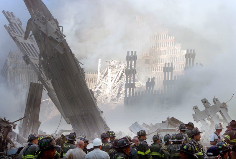 A group of firefighters stand near the
destroyed World Trade Center in New York on September 11, 2001.