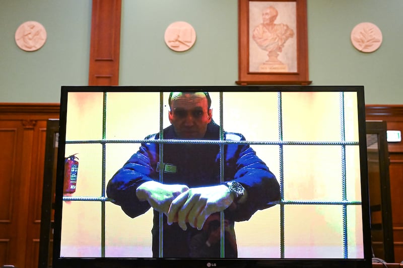TOPSHOT - Opposition leader Alexei Navalny appears on a screen set up at a courtroom of the Moscow City Court via a video link from his prison colony during a hearing of an appeal against his nine-year prison sentence he was handed in March after being found guilty of embezzlement and contempt of court, in Moscow on May 17, 2022. Alexei Navalny's hearing comes as Russian authorities seek to silence remaining government critics and Moscow pushes on with its military campaign in neighbouring Ukraine, with thousands killed and some 10 million displaced. He is already serving two-and-a-half years in a prison some 100 kilometres (60 miles) east of Moscow for violating parole on old fraud charges. If his new sentence comes into force, the 45-year-old opposition politician will be transferred to a strict-regime penal colony, which will place him in much harsher conditions. The new sentence will replace the old one -- that he was handed in February last year -- meaning Navalny will remain behind bars for another eight years. (Photo by Kirill KUDRYAVTSEV / AFP) (Photo by KIRILL KUDRYAVTSEV/AFP via Getty Images)