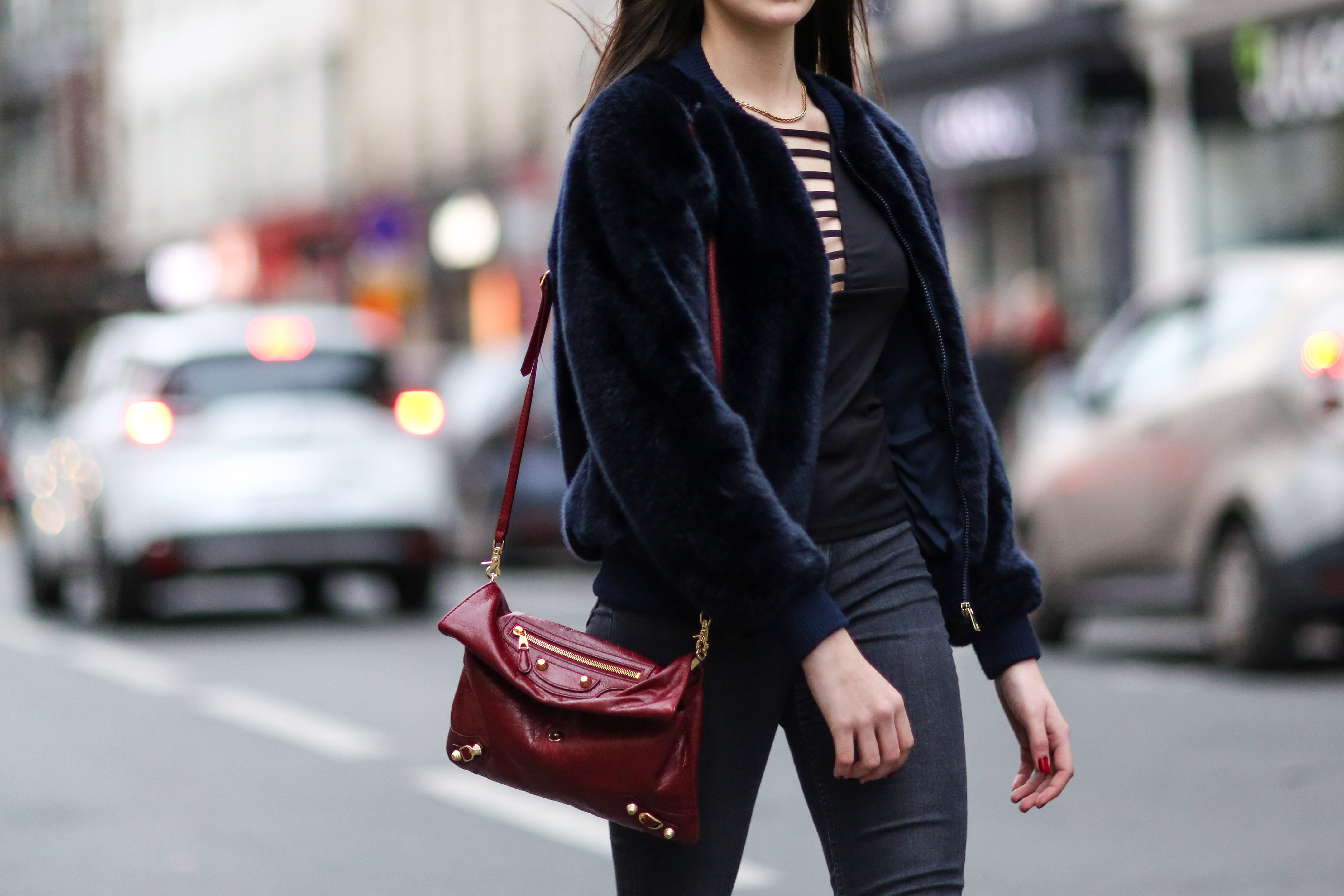 Woman wearing velvet jacket with maroon purse and low-rise pants