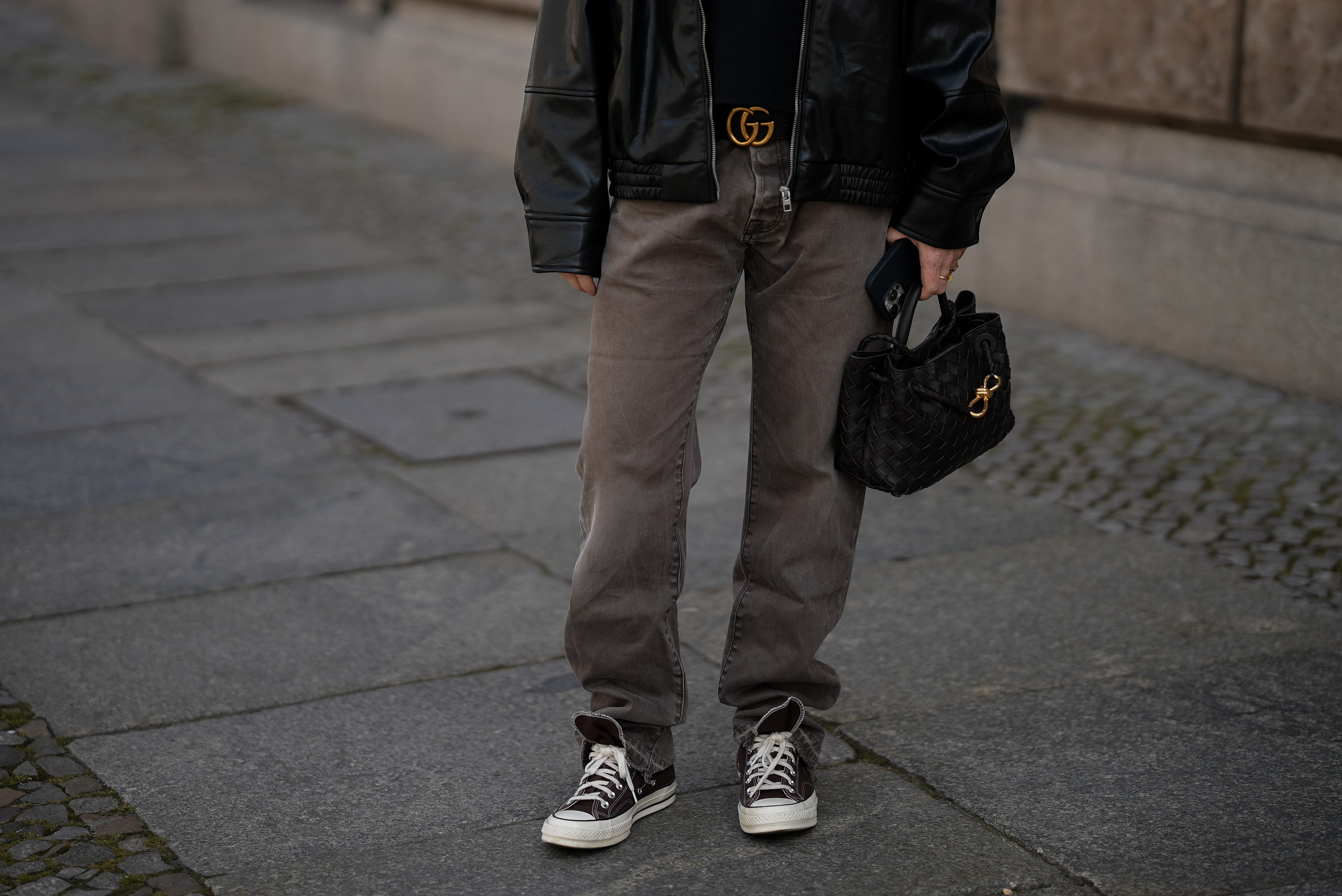 Man with Gucci belt, jeans, sneakers, and bag
