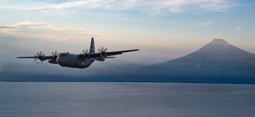 A U.S. Air Force C-130H3 Hercules aircraft, including a 94th Airlift Wing tail insignia that dates to World War II, flies away from Mount Fuji, Japan, after airdrop operations on July 28, 2025.