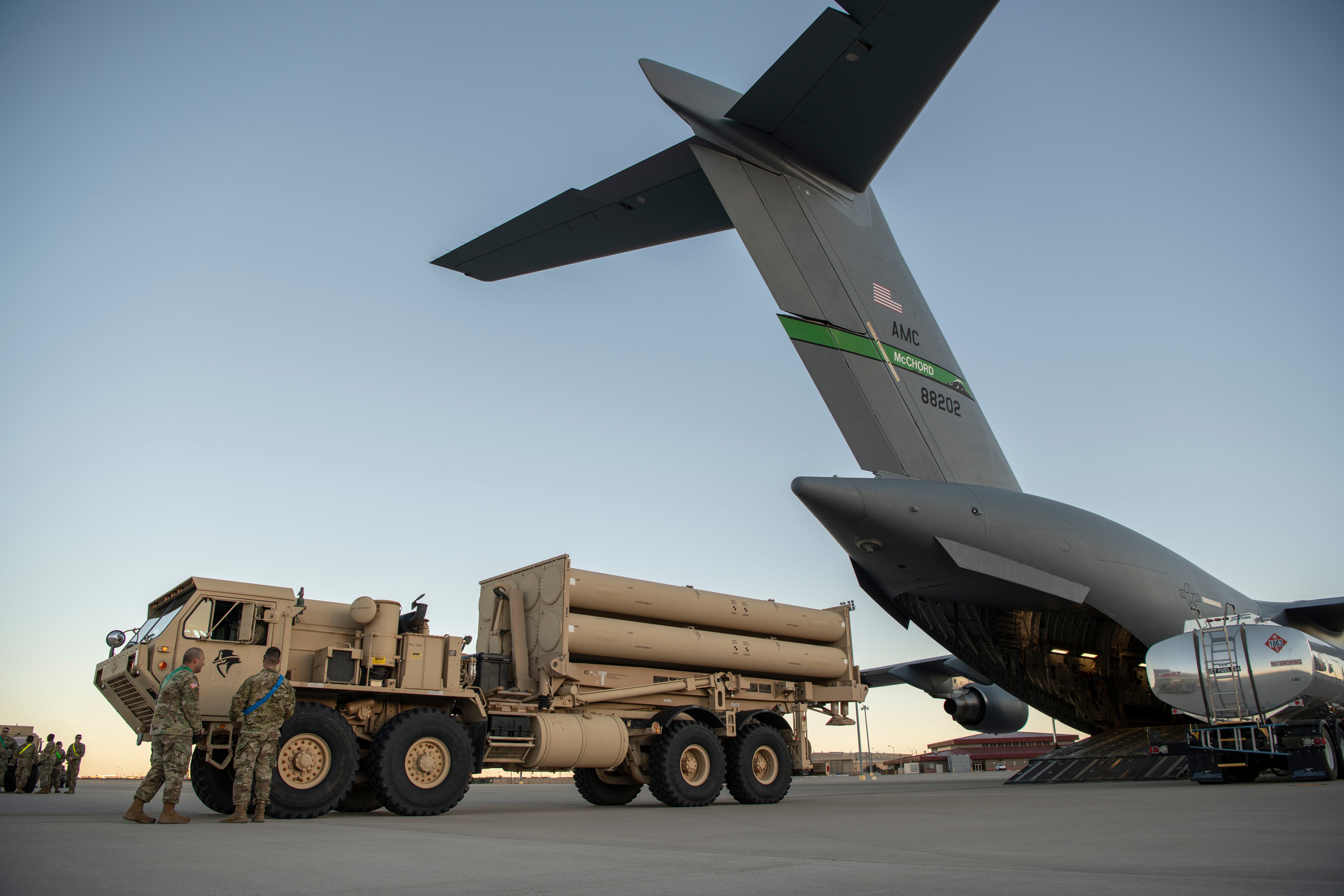 A THAAD launcher next to an aircraft.