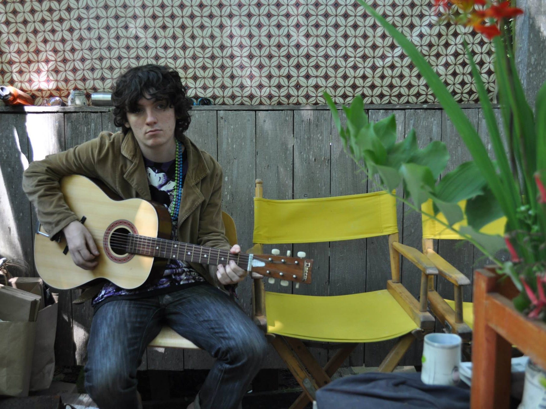 Nikolai Smirnoff, at 15 years old, is playing a guitar outside in Hong Kong.