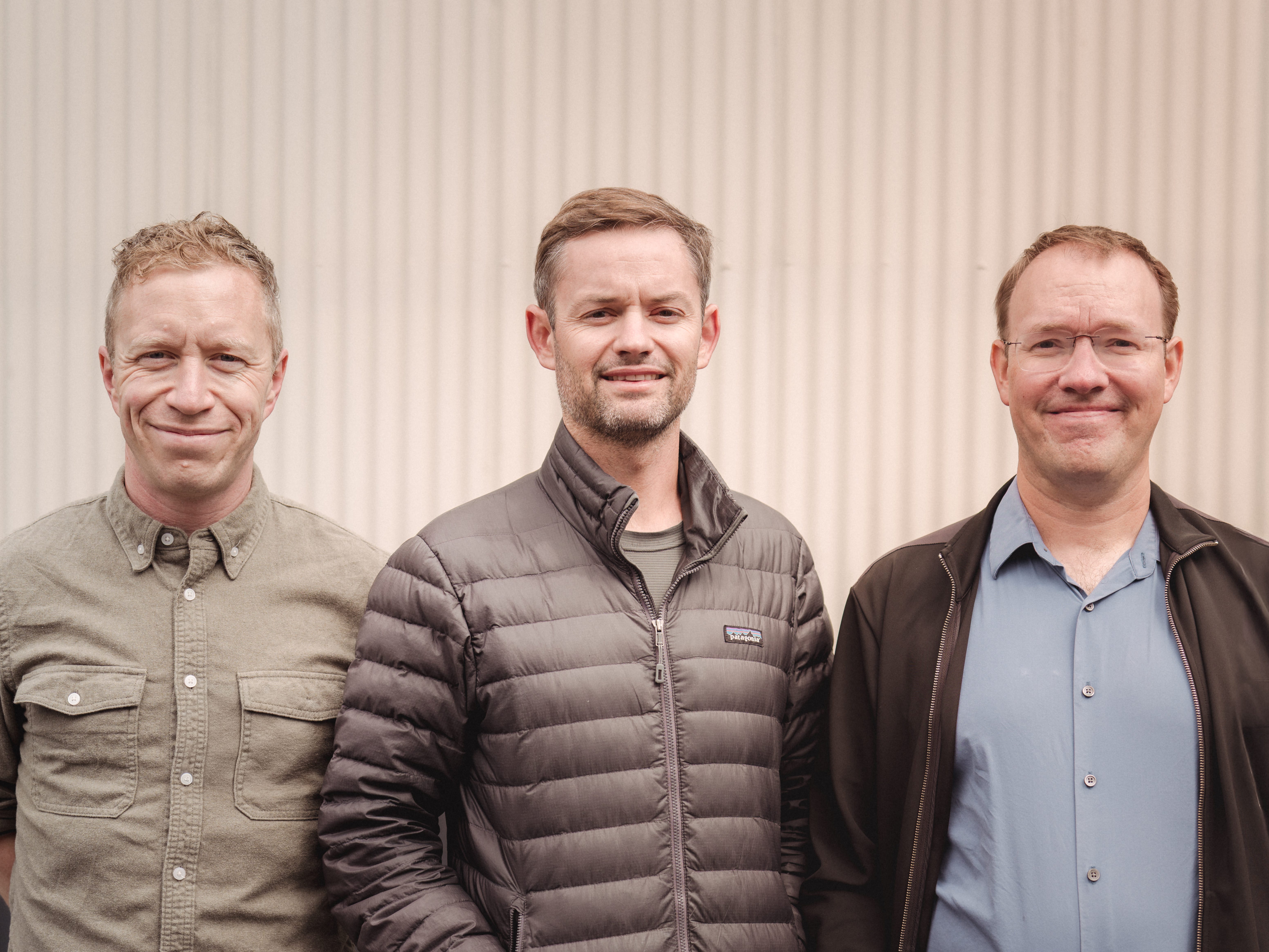 Tim Donnelly, Kyle Macomber, and Jacob Xiao, standing in front of a beige wall.