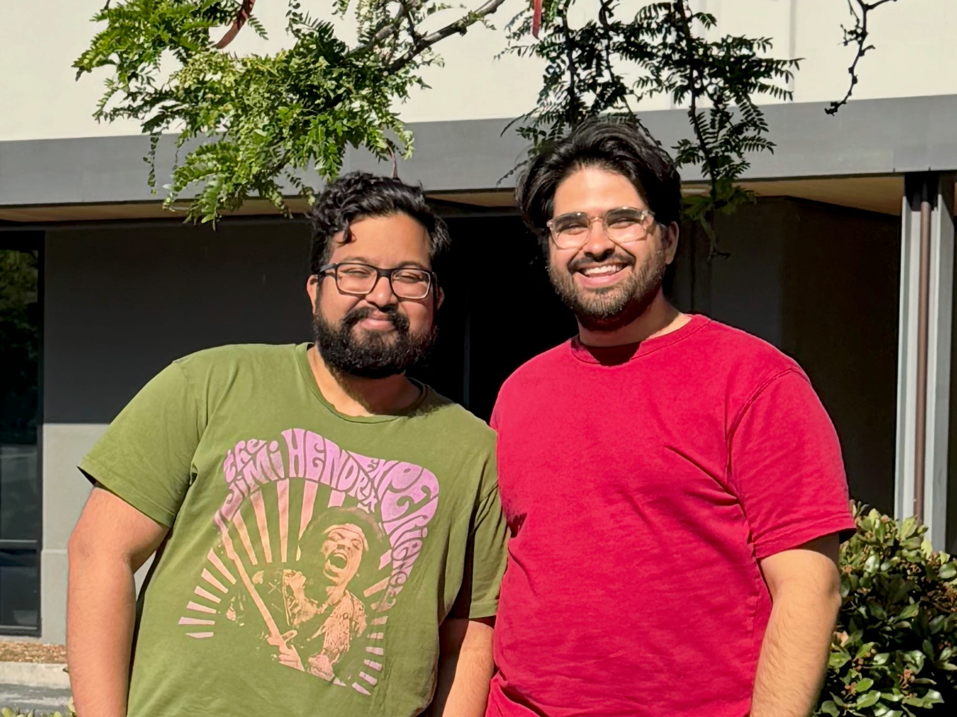 Saurav Mitra and Mahyad Ghassemibouyaghchi, standing outside in front of a Y Combinator sign.
