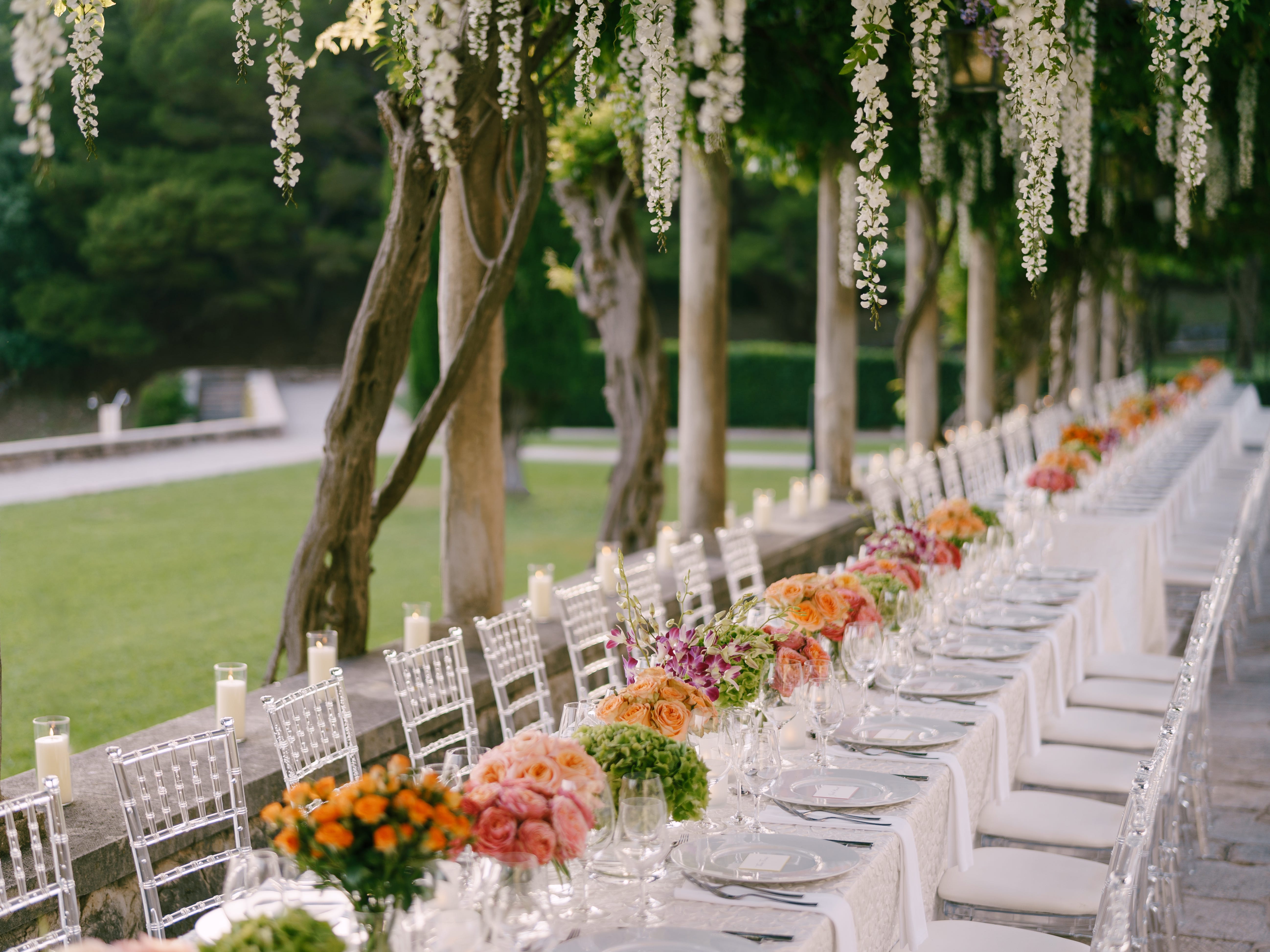 A long table for wedding guests, complete with floral centerpieces down the middle.
