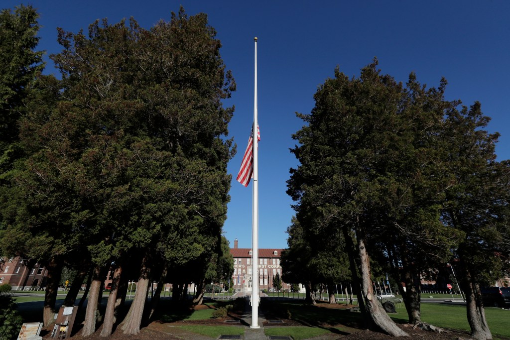 US flag at half-mast in front of a building.