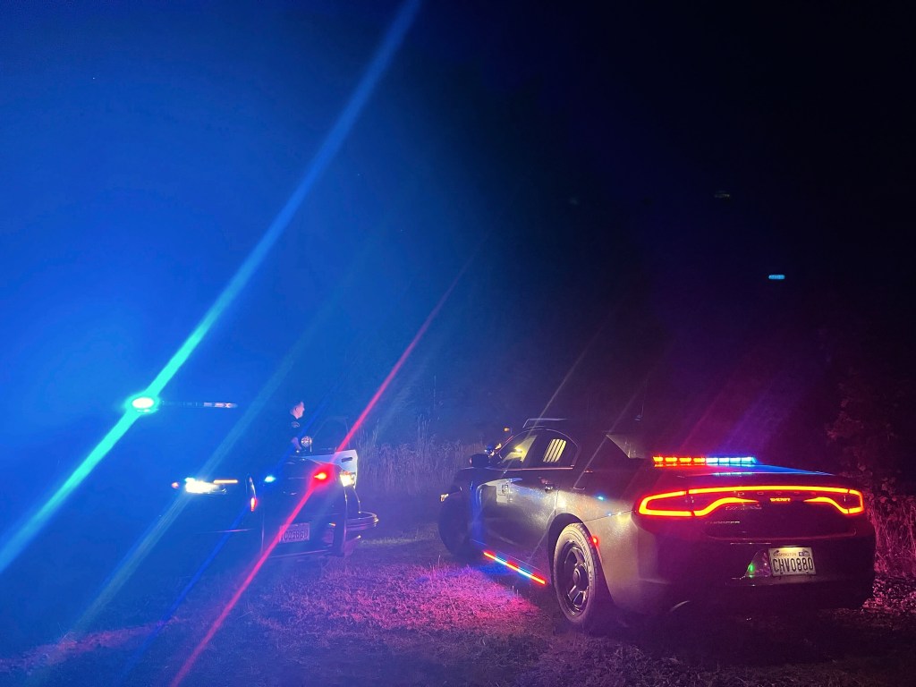 Police cars at night at a US Army helicopter crash site.
