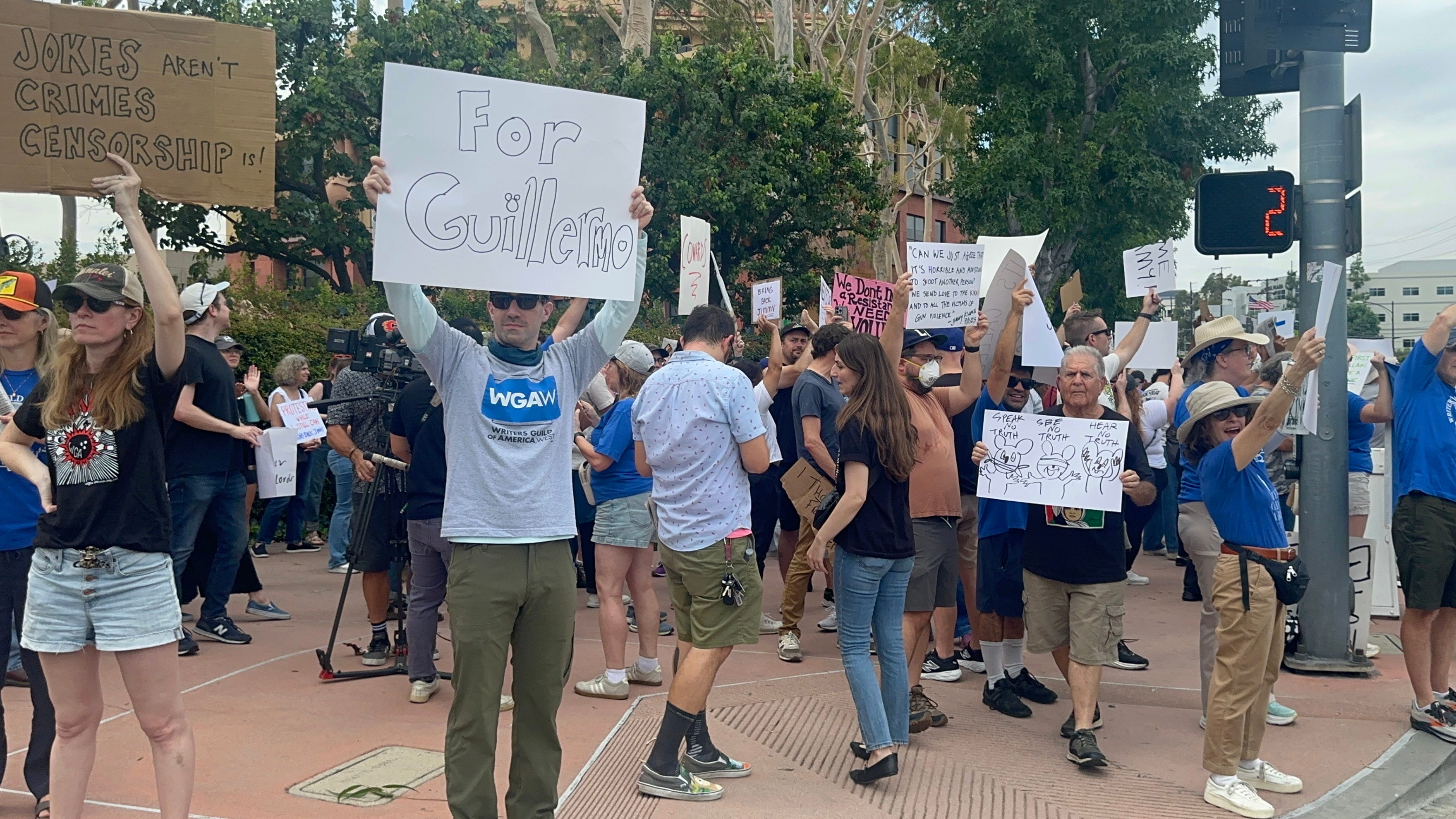 Protesters at Disney, including one with a sign that says 