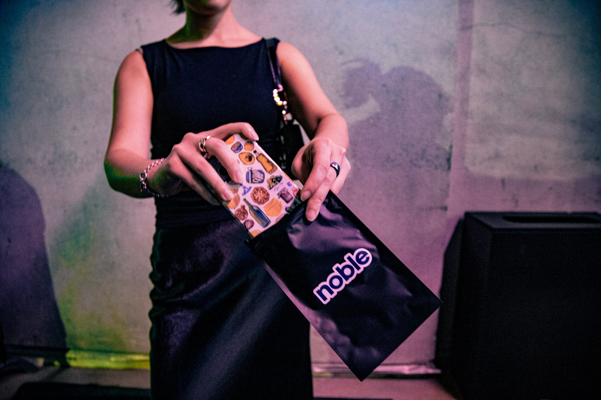 A woman slips an iPhone into a black pouch.