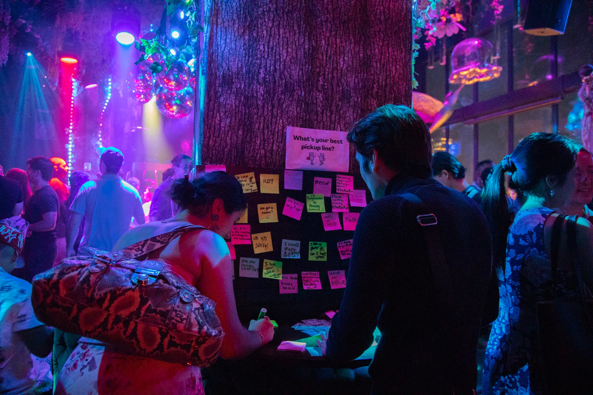 People write on Post-Its at a party.
