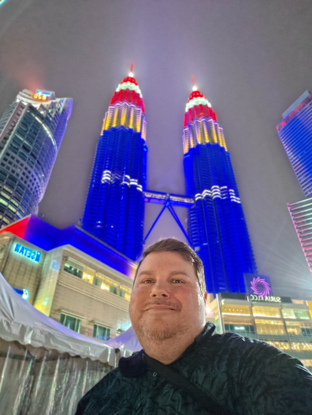 Jerry Massey in Kuala Lumpur, Malaysia, in front of the Petronas
Twin Towers lit up at night.
