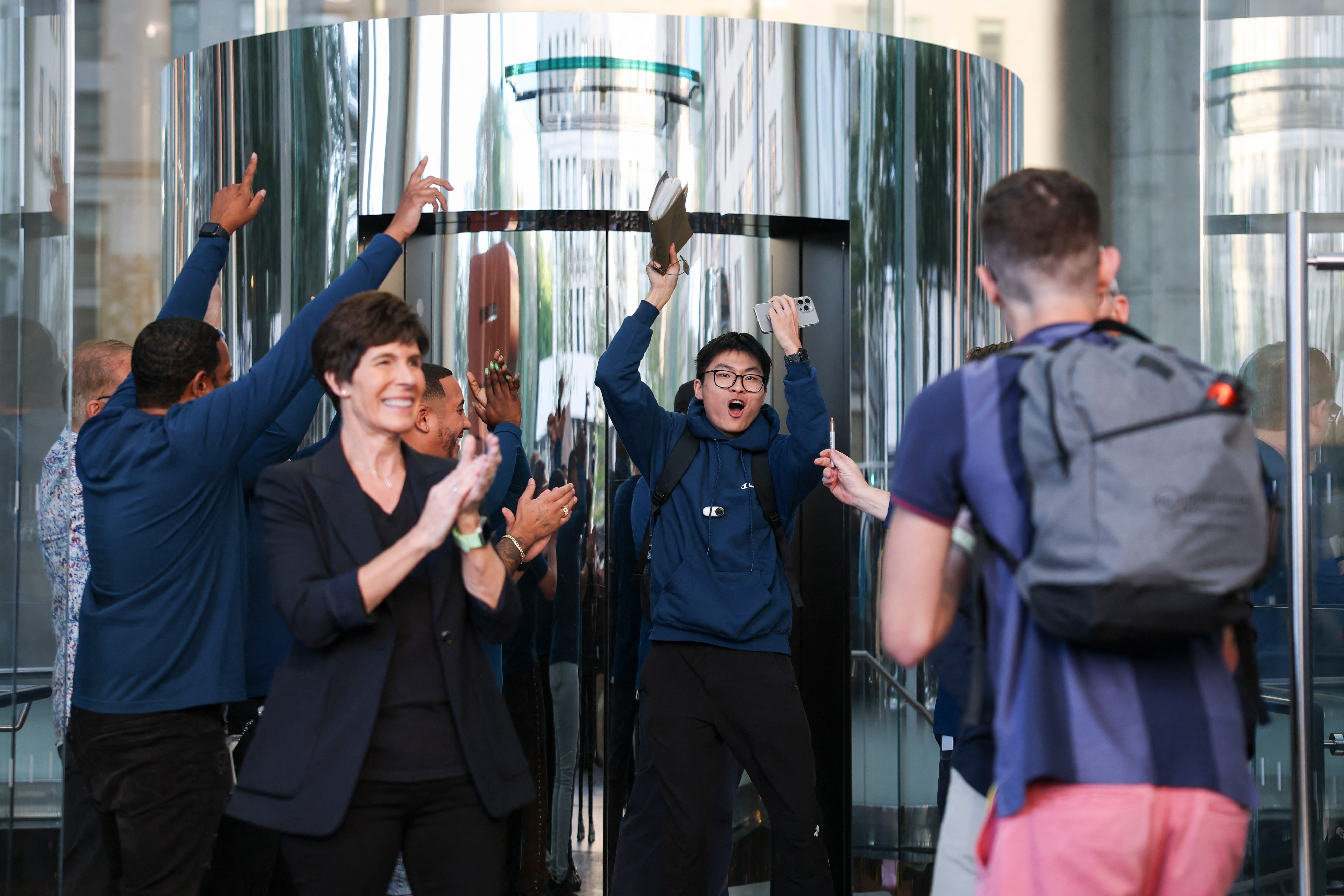A customer cheer's leaving the Apple Store in New York.