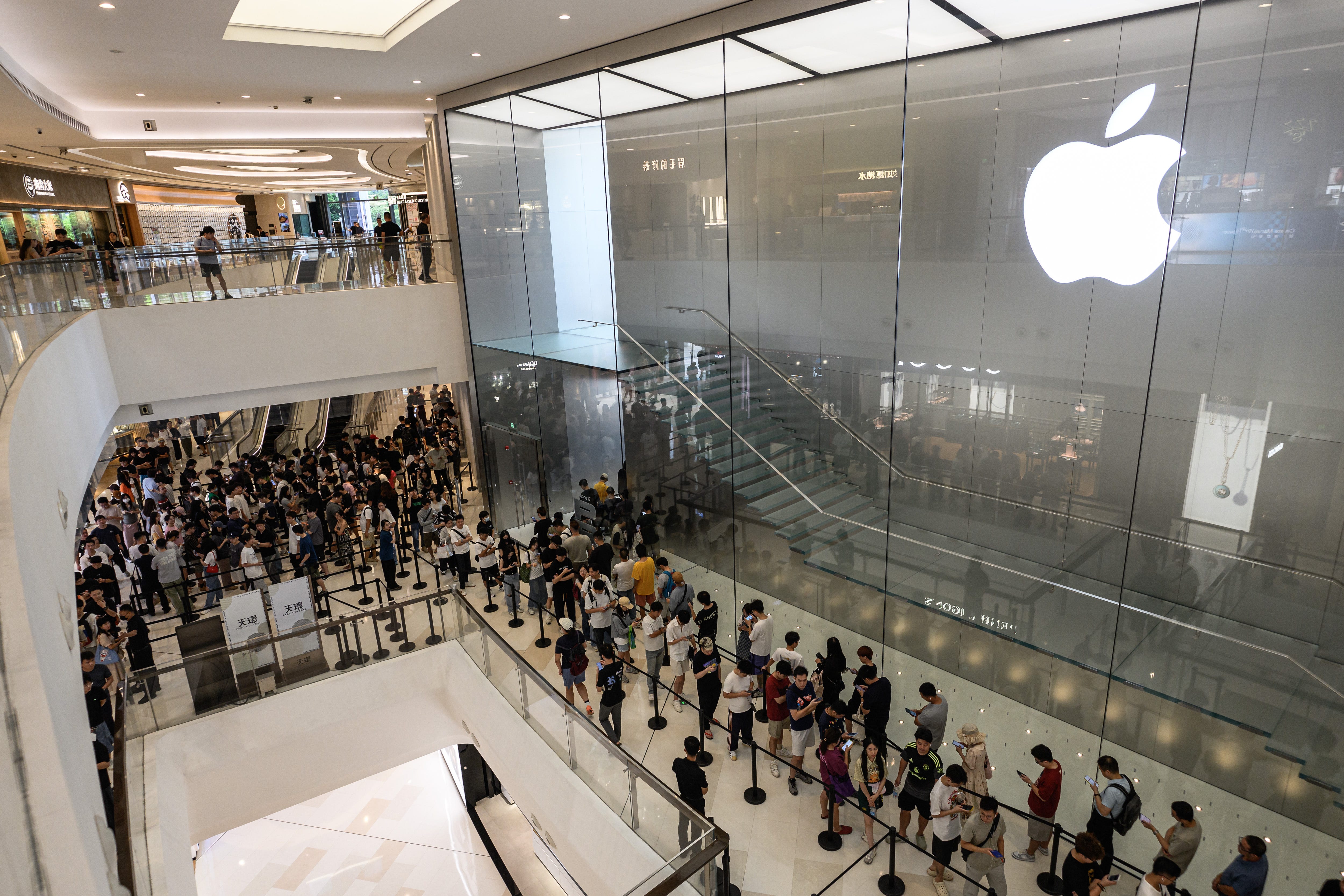 Customers are pictured in the Apple store line in Guangzhou, Guangdong Province of China.