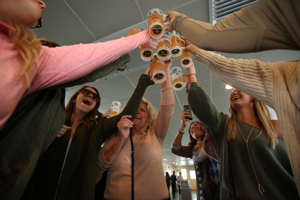 Women toasting beer steins on a boat.