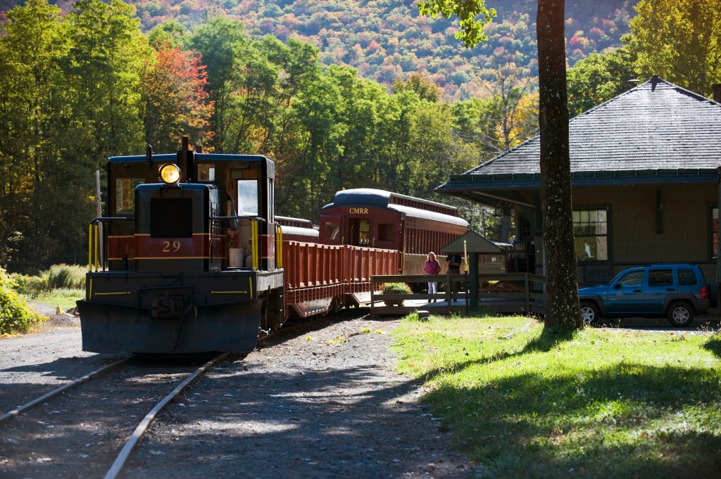A scenic train arriving at a station in the Catskill Mountains.