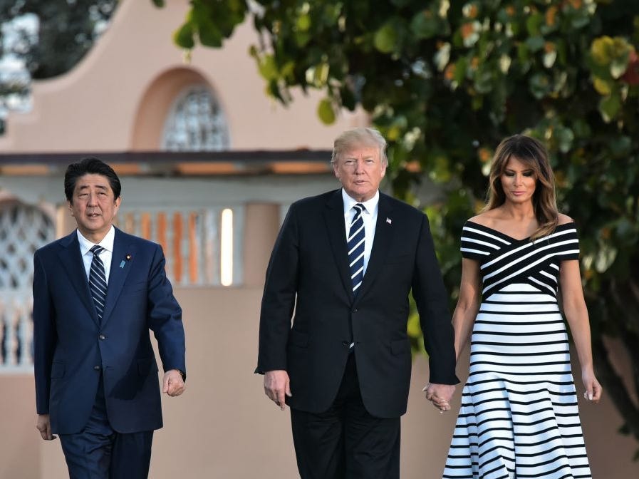 Donald Trump and Melania Trump wear matching stripe outfits while walking with Japan's prime minister.