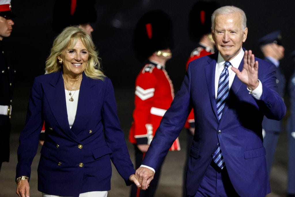 President Joe Biden and Dr. Jill Biden walk while holding hands.