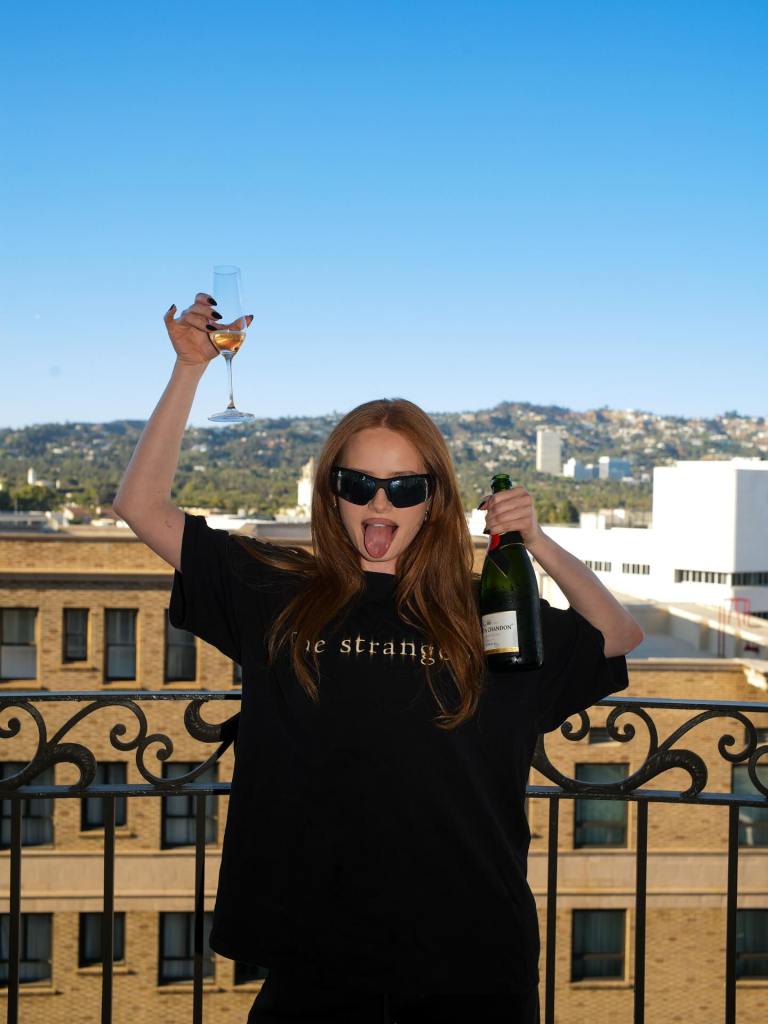 Madeline Petsch toasts on a balcony. 