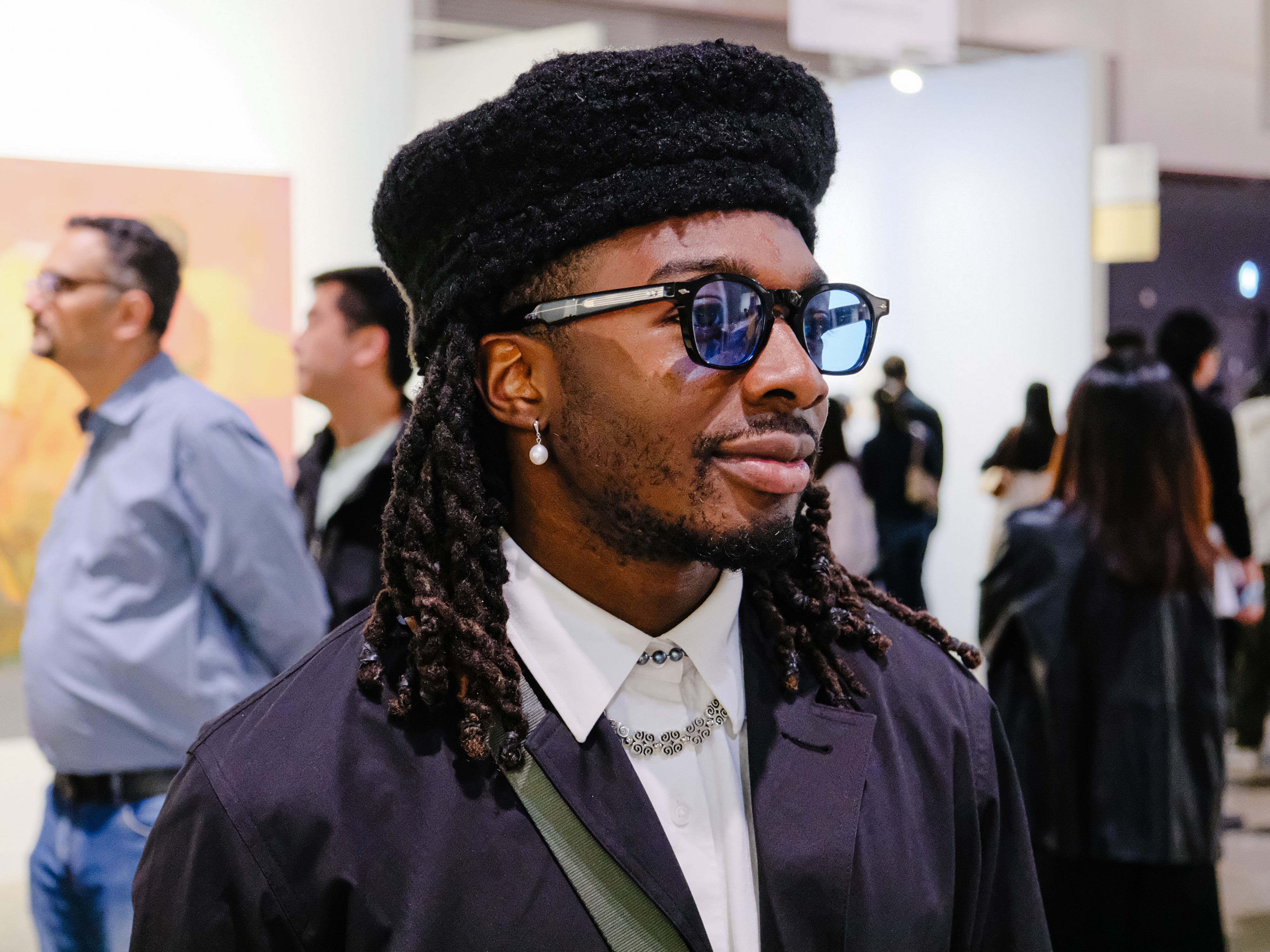 A person at Art Basel 2025 wears Jacques Marie Mage glasses and a Beekite hat.