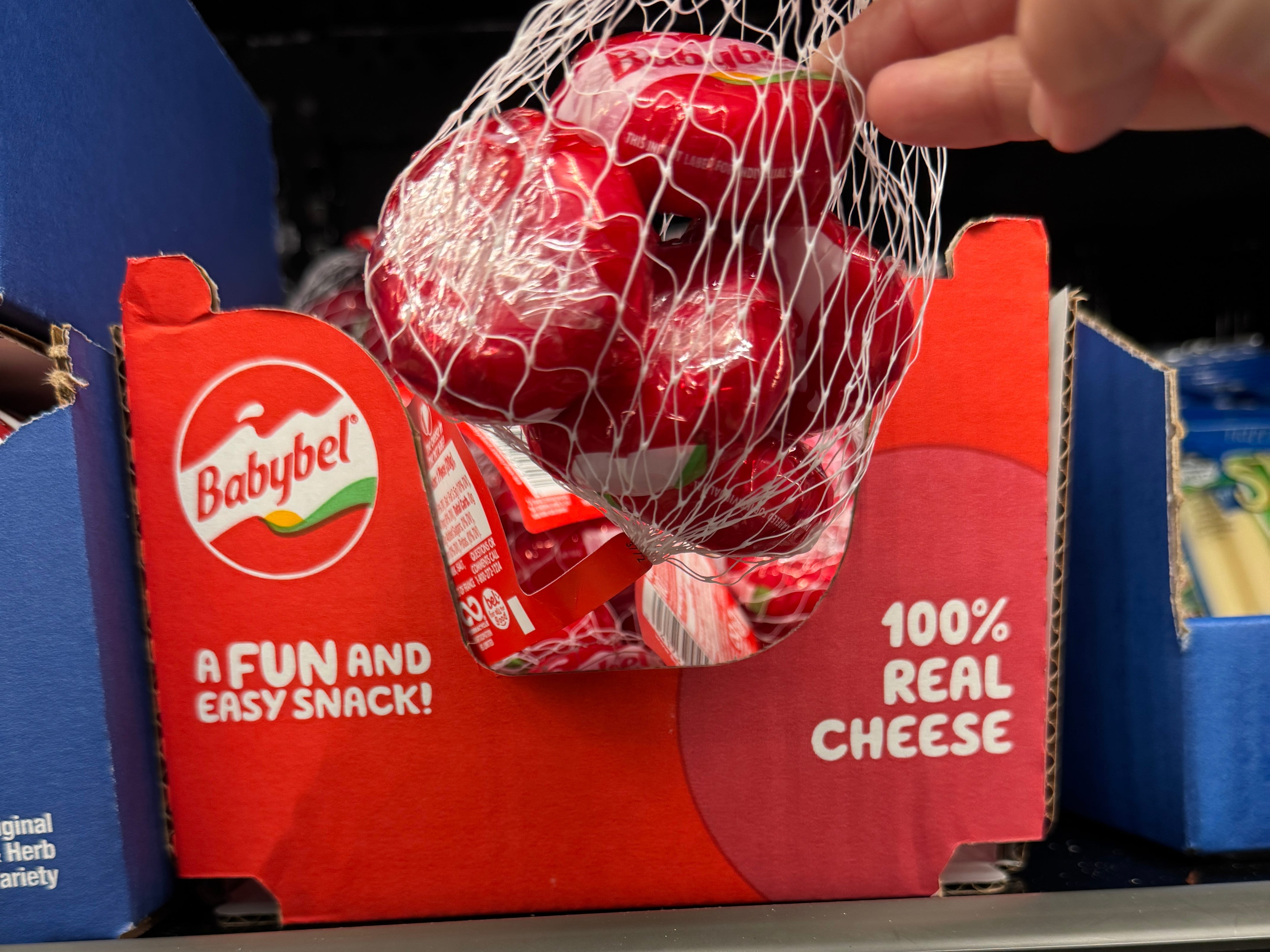 The author holding a bag of Babybel cheese at Aldi.