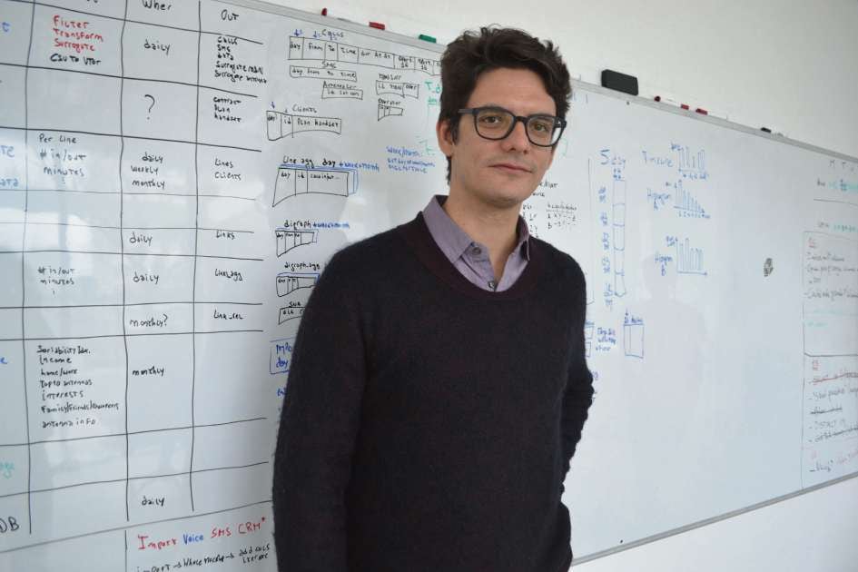 Matías Travizano in front of a whiteboard filled with diagrams and notes.