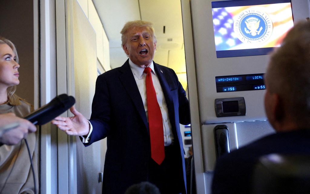 Donald Trump speaks to reporters aboard Air Force One.