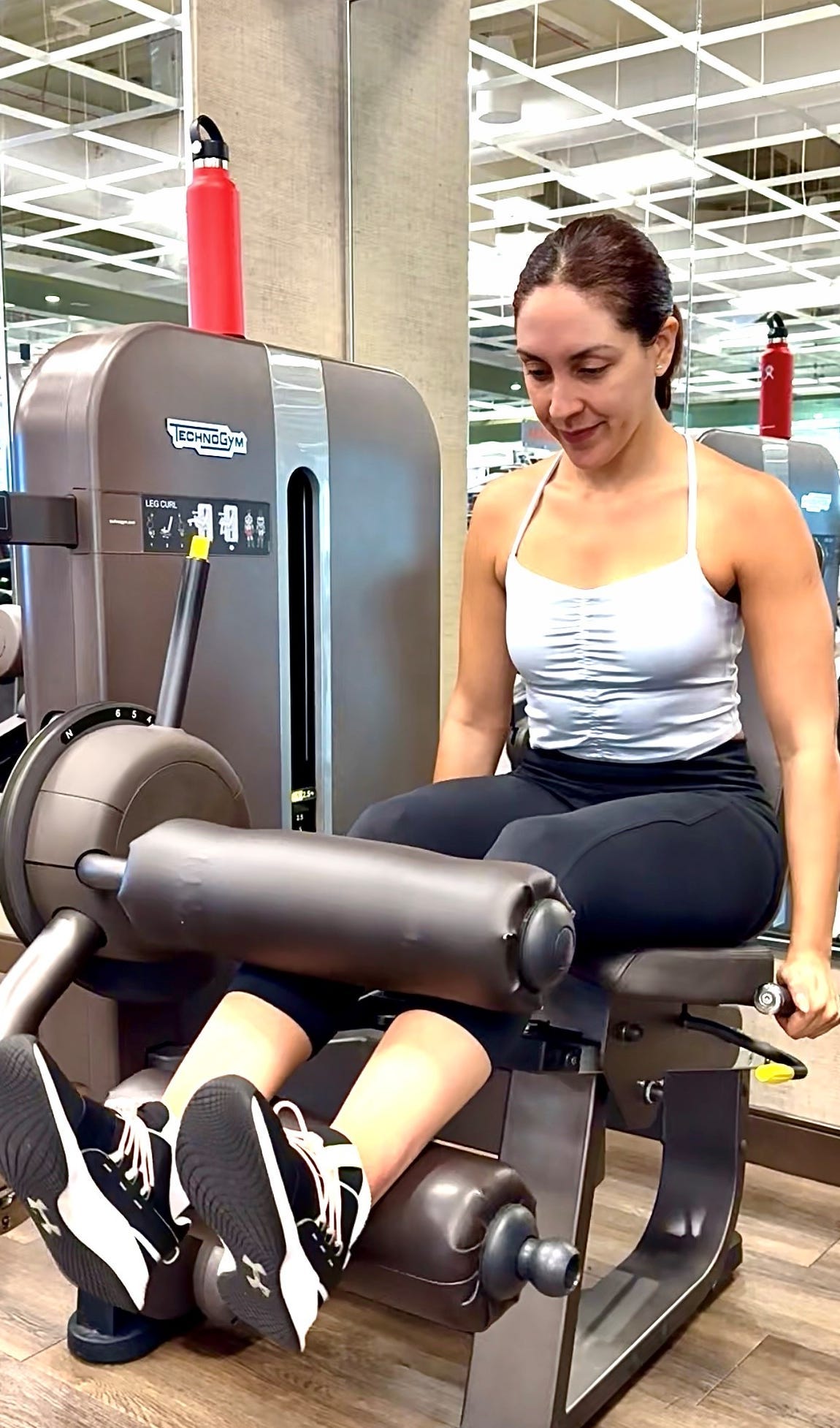 A woman lifting weights on a gym machine doing a leg workout