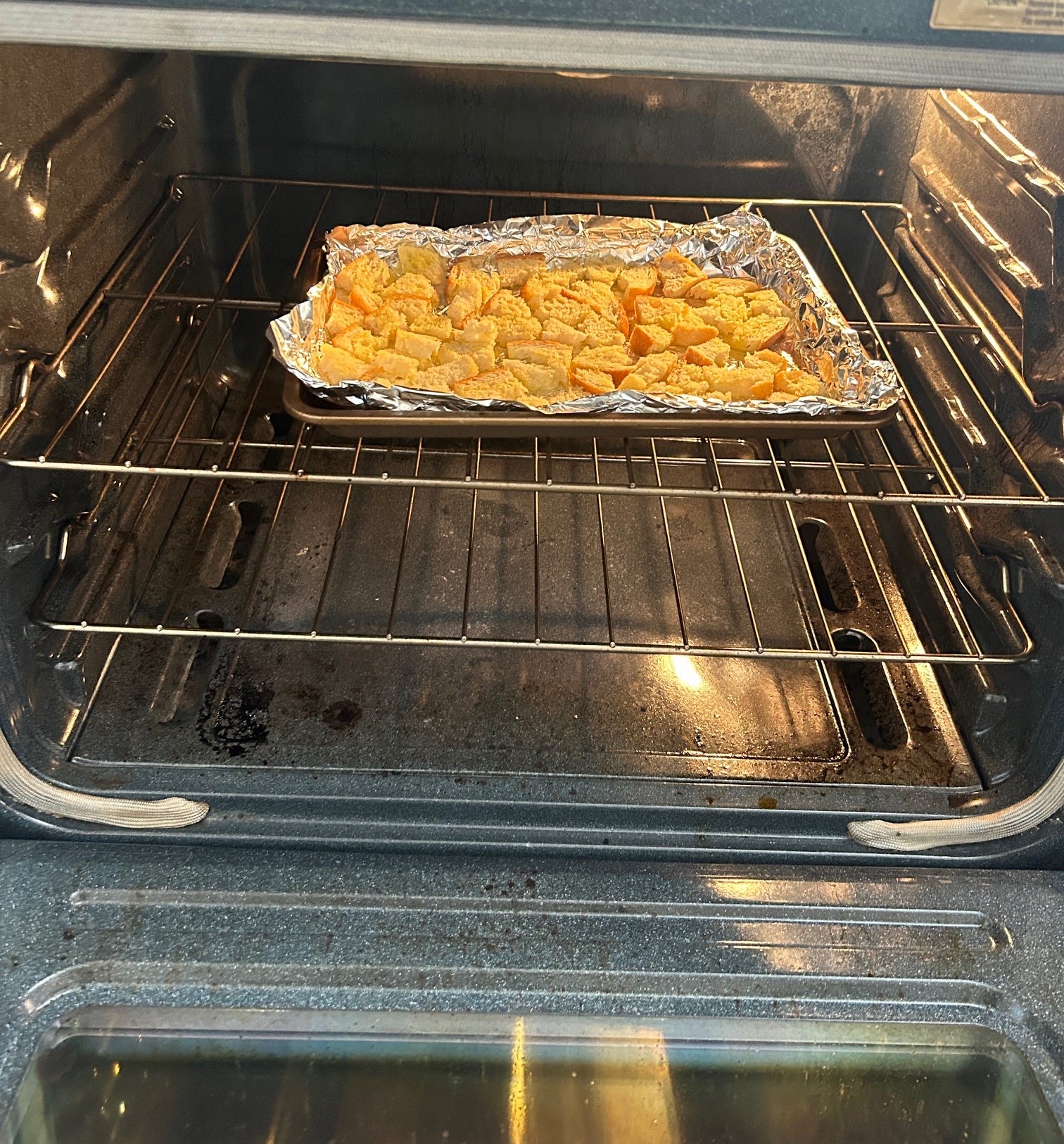 Putting homemade croutons in the oven for Meghan Markle's Roasted Chicken and Bread Salad