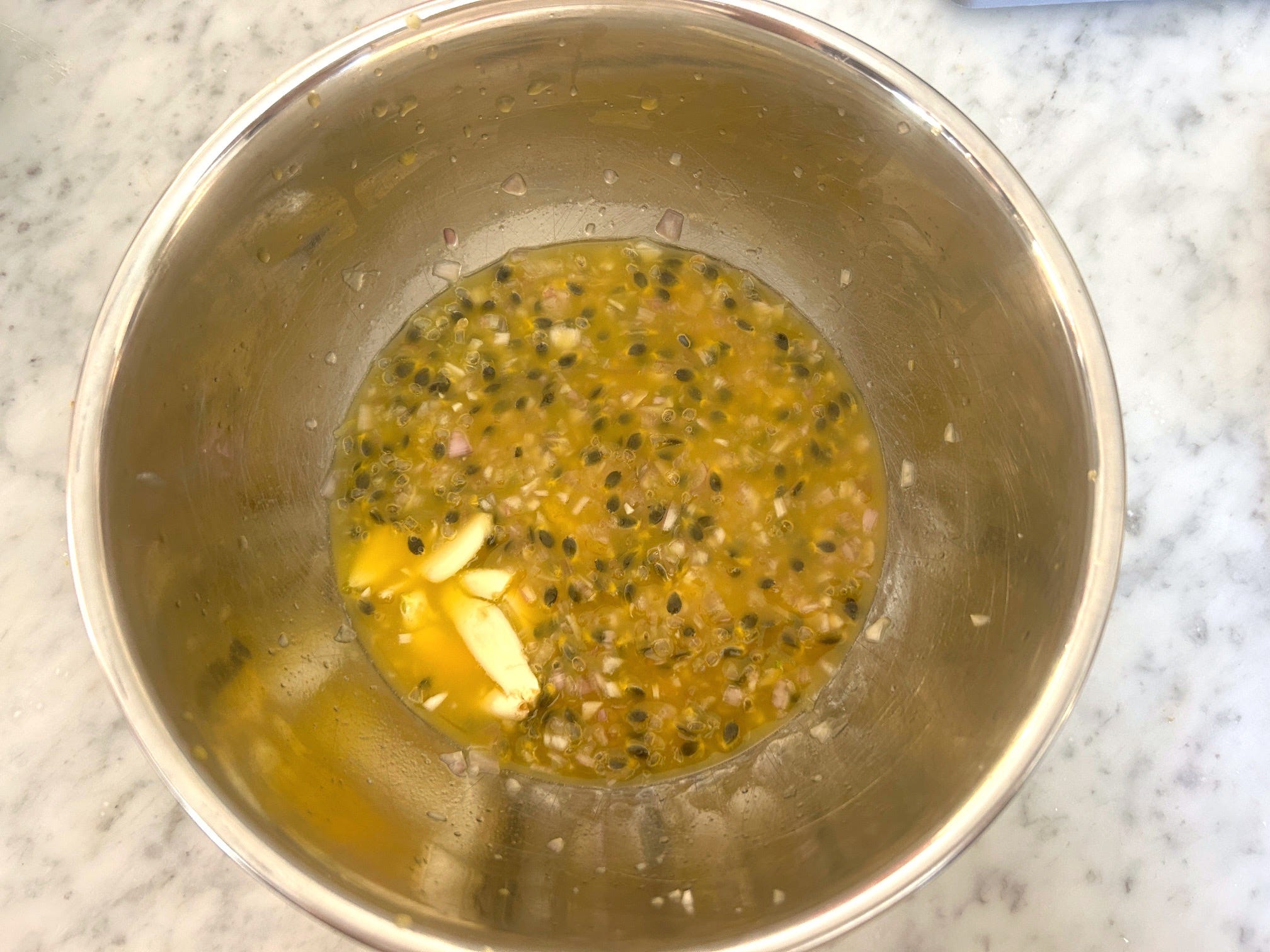 Adding garlic to the passionfruit dressing for Meghan Markle Roasted Chicken and Bread Salad