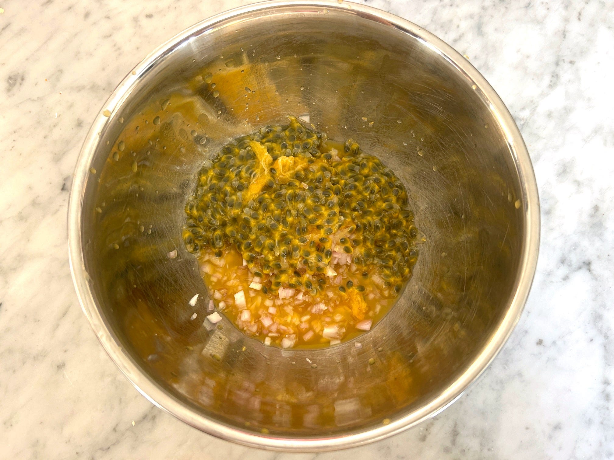Mixing passionfruit with shallot for Meghan Markle Roasted Chicken and Bread Salad
