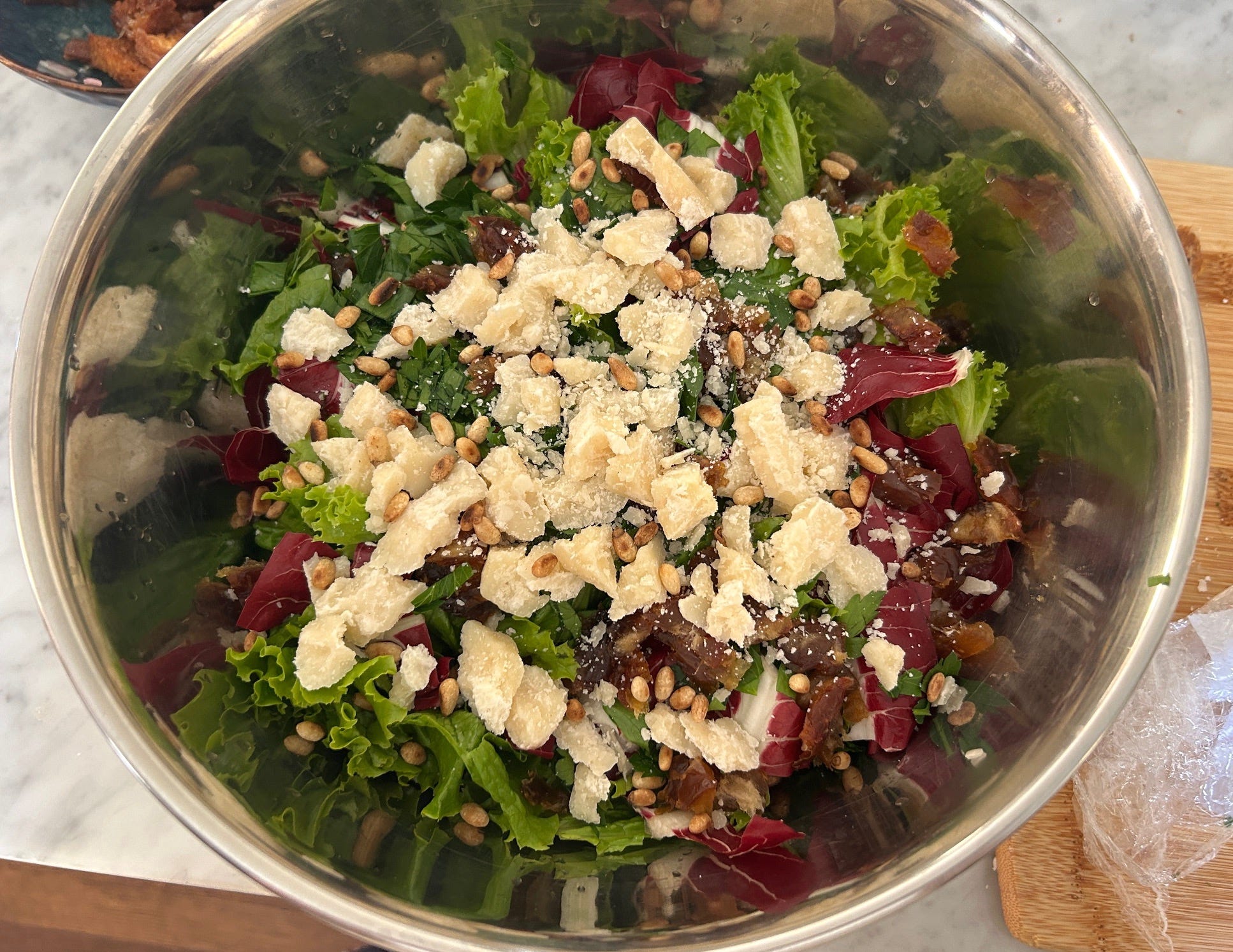 Adding chicken and pine nuts to Meghan Markle Roasted Chicken and Bread Salad