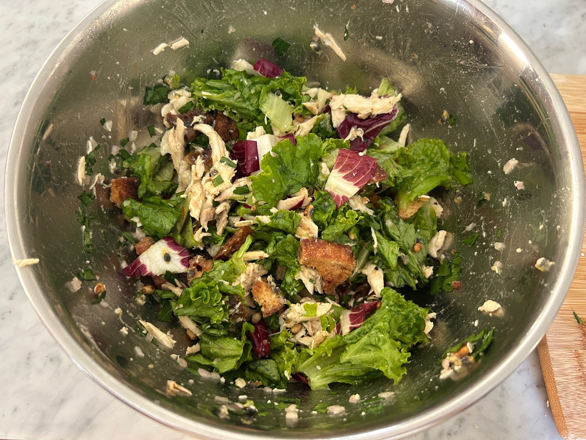 Mixing ingredients for Meghan Markle Roasted Chicken and Bread Salad