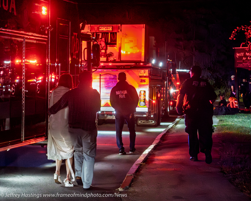 People stand near fire trucks at night at Sky Meadow Country Club following a deadly shooting.