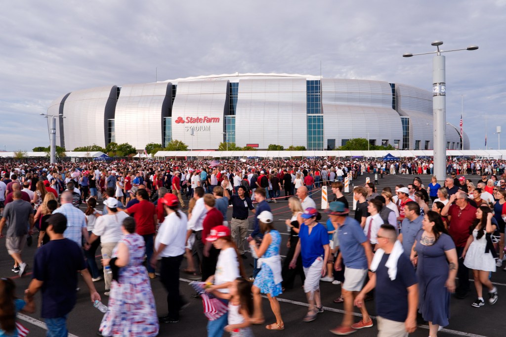 A crowd of people walk towards State Farm Stadium in Glendale, Arizona for a memorial service for slain conservative commentator Charlie Kirk.
