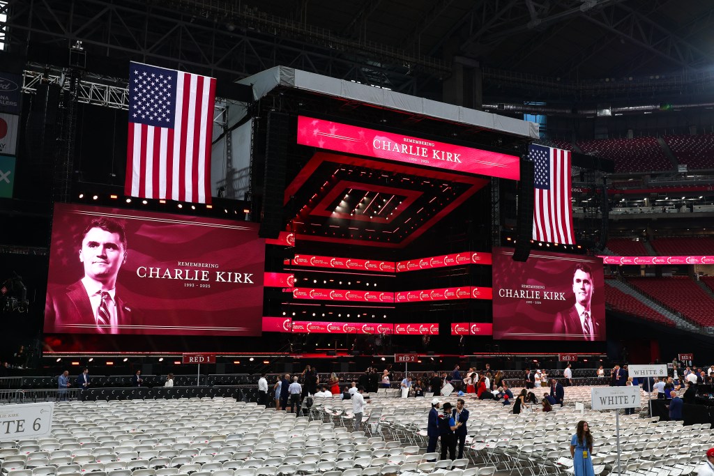 Stage setup for Charlie Kirk's memorial service with large screens displaying his image and 