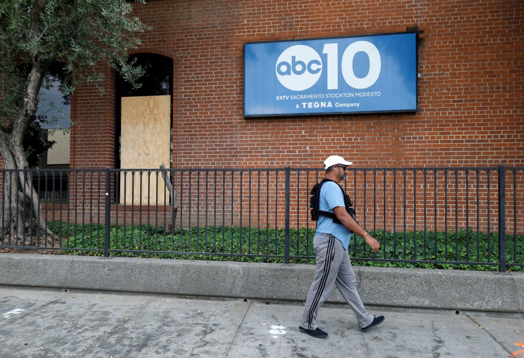 A man walks past ABC10’s damaged lobby window on Friday -- a day after the gunfire rattled the station.