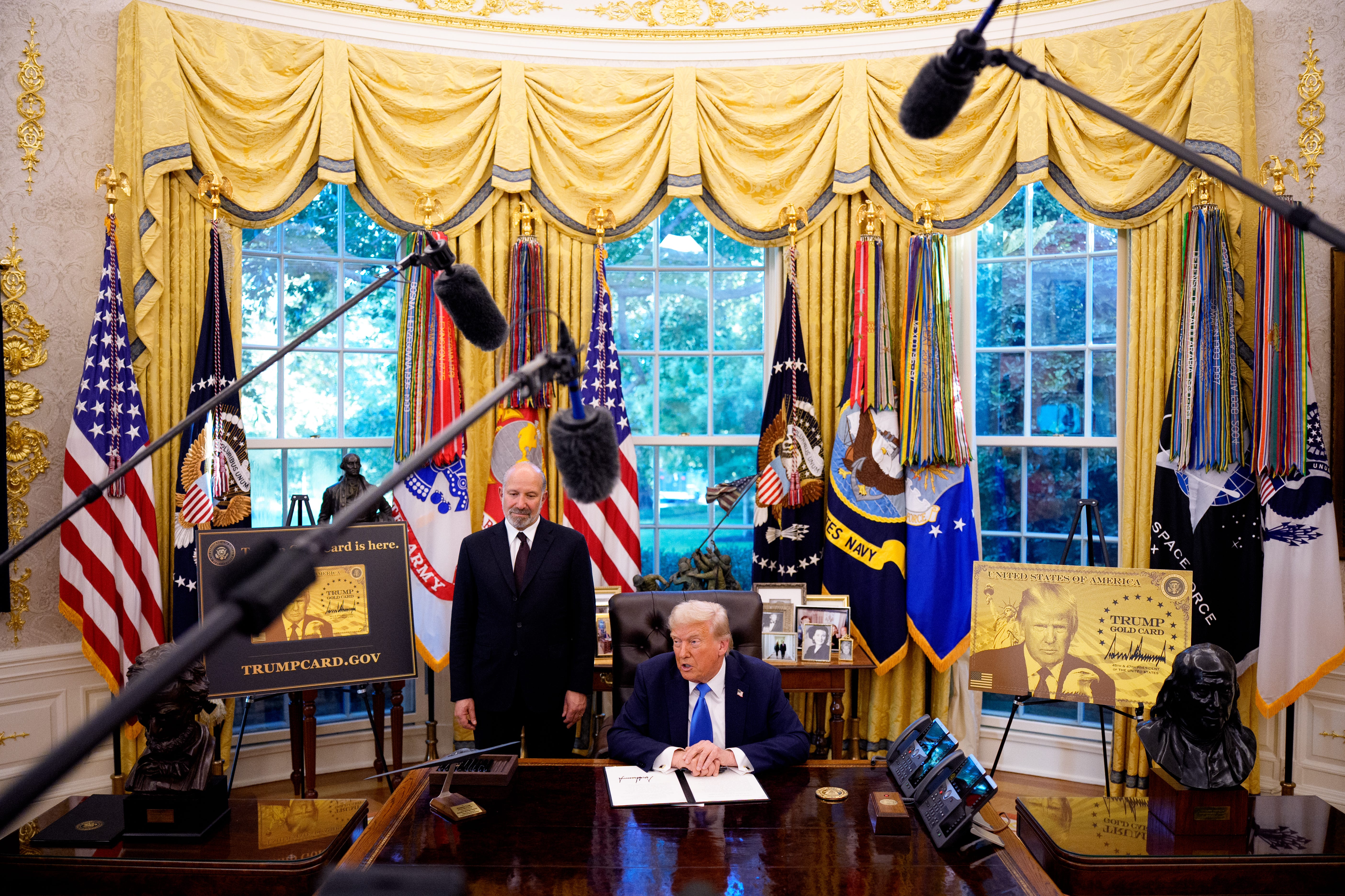 President Donald Trump, accompanied by Commerce Secretary Howard Lutnick, speaks after signing an executive order imposing a $100,000 fee on H1B visas in the Oval Office at the White House.