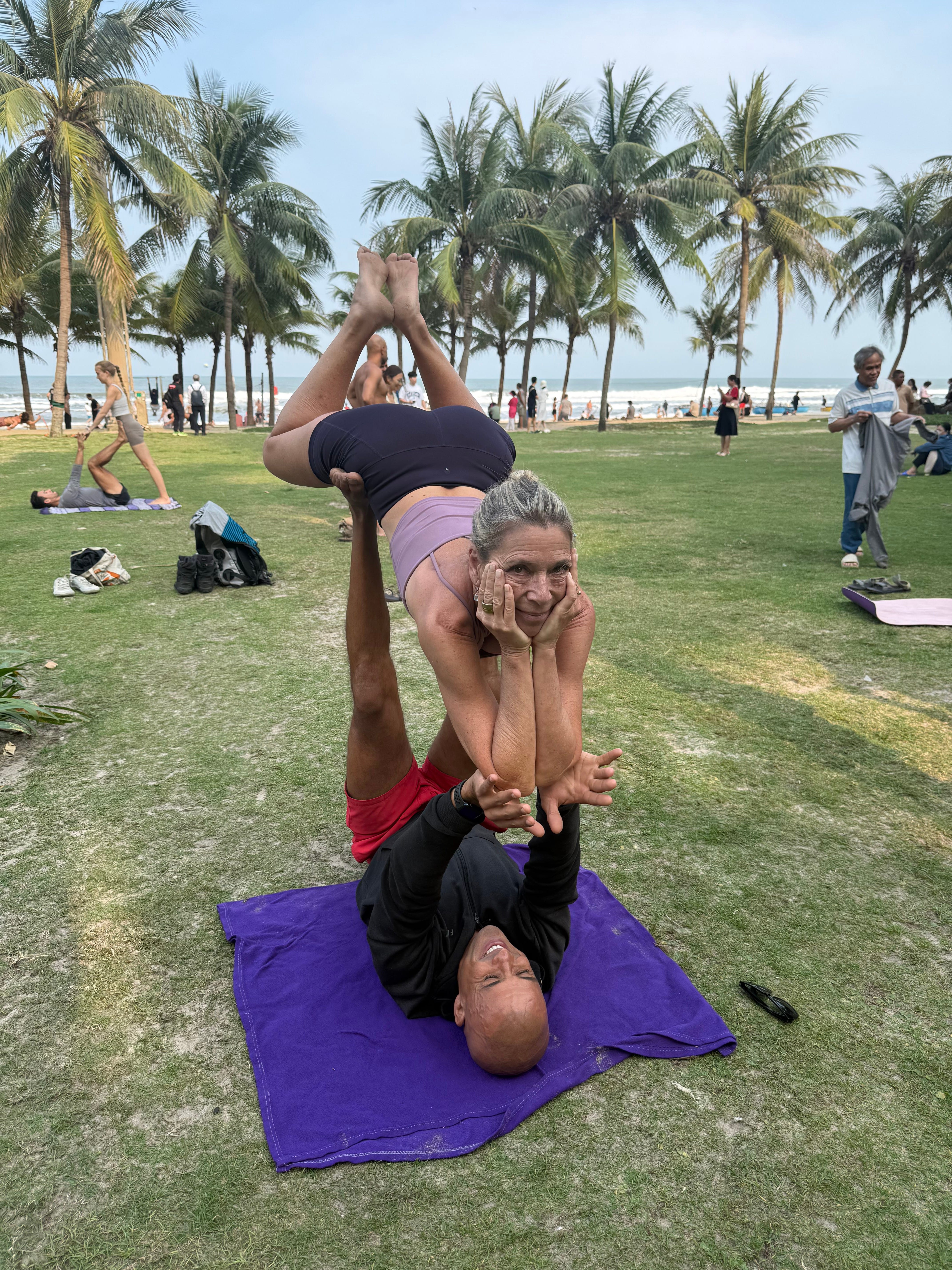 A woman practicing acrobatic yoga with a partner