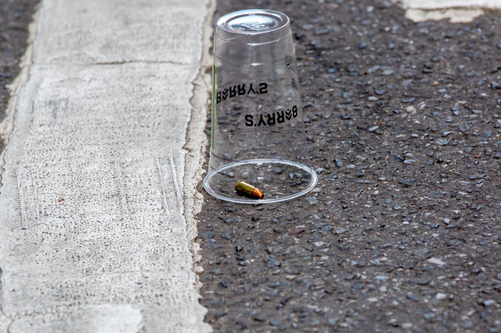 Bullet casing under a clear cup on the asphalt near E 27th St and Park Ave in Midtown Manhattan.