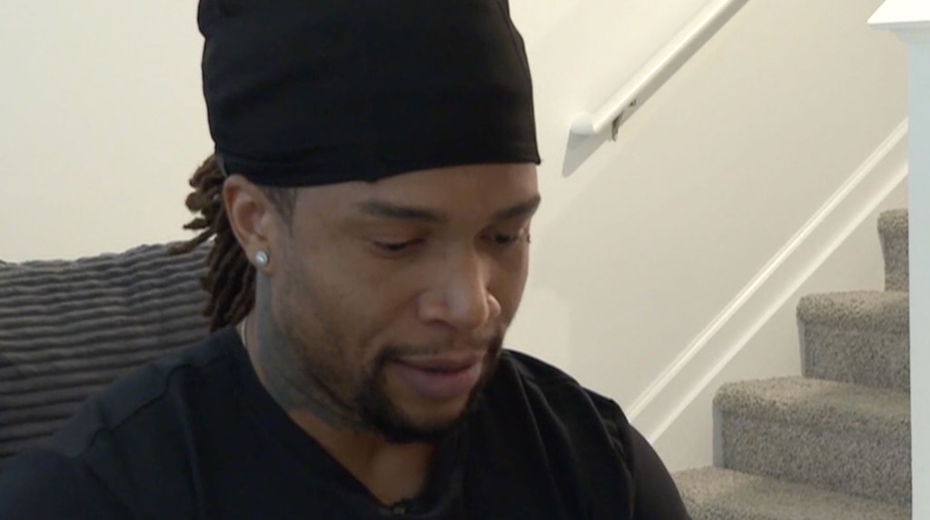 Man with dreadlocks wearing a black durag and t-shirt.