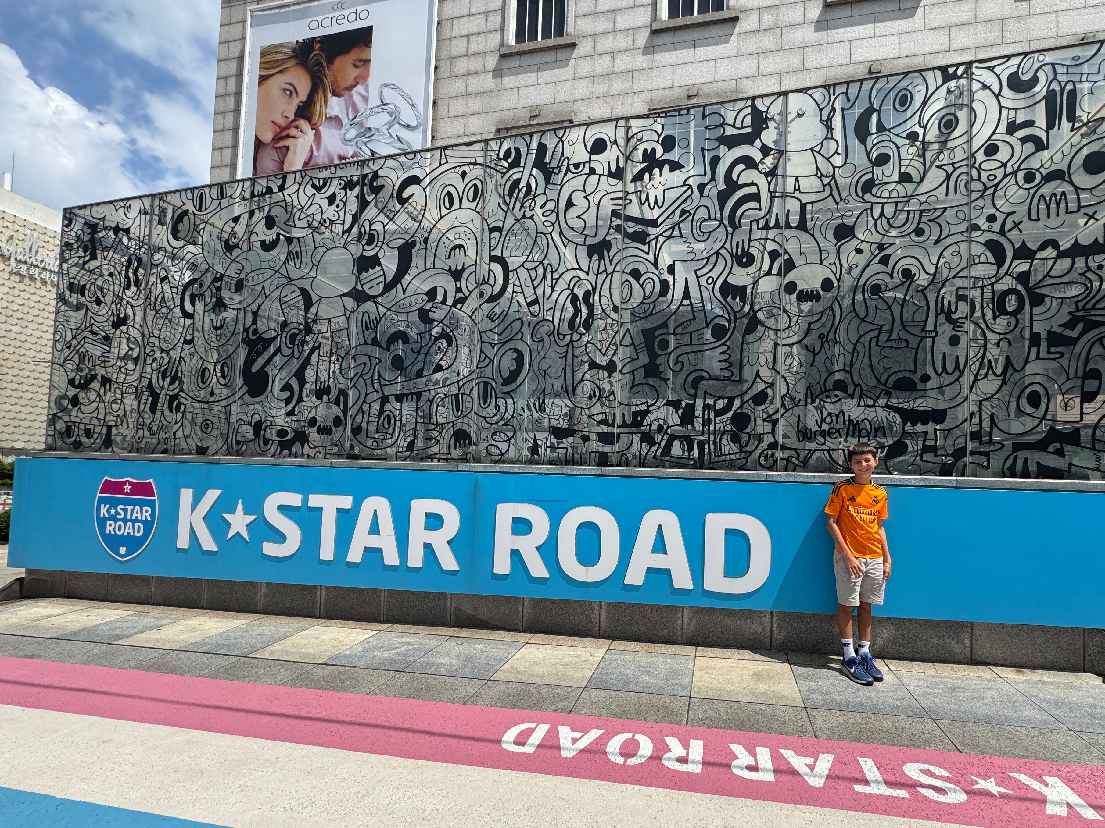 The author's son poses in front of a sign for K-Star Road in South Koreal