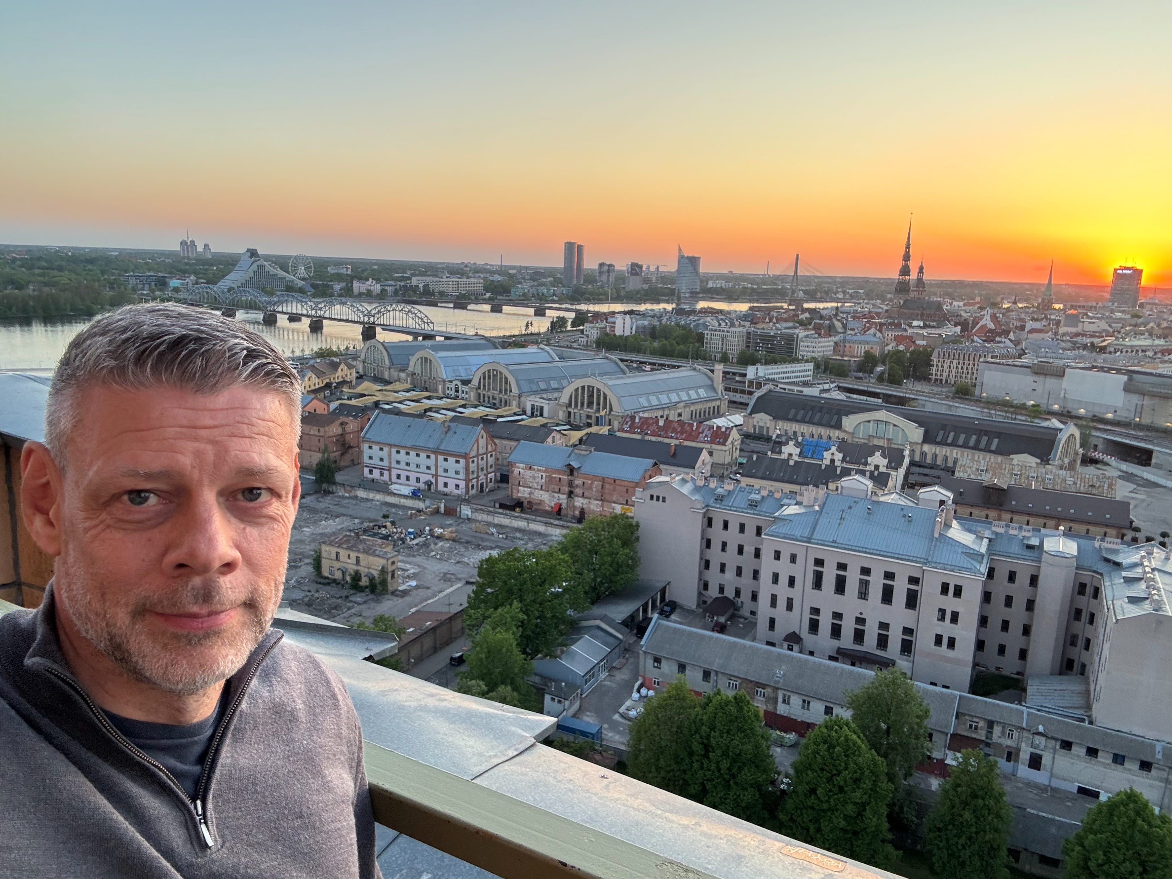 The author taking a selfie on a rooftop in Riga, Latvia, at sunset.