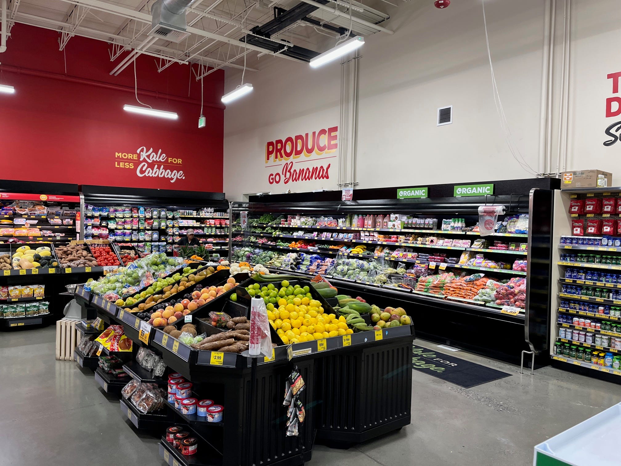 The produce section at Grocery Outlet, with slogans painted on the wall, including