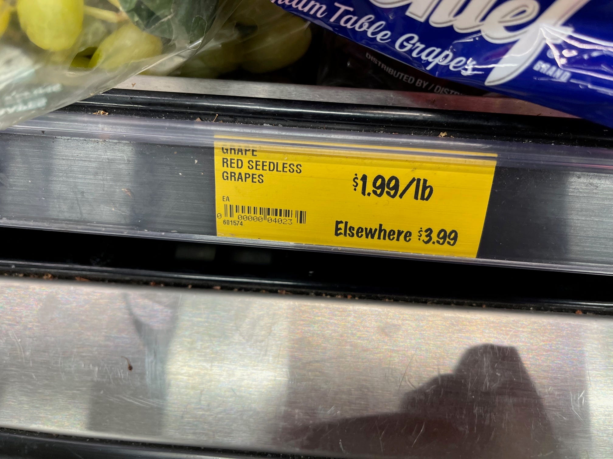 A shelf tag at Grocery Outlet lists the price of red seedless grapes as $1.99 a pound -- and mentions that similar grapes sell