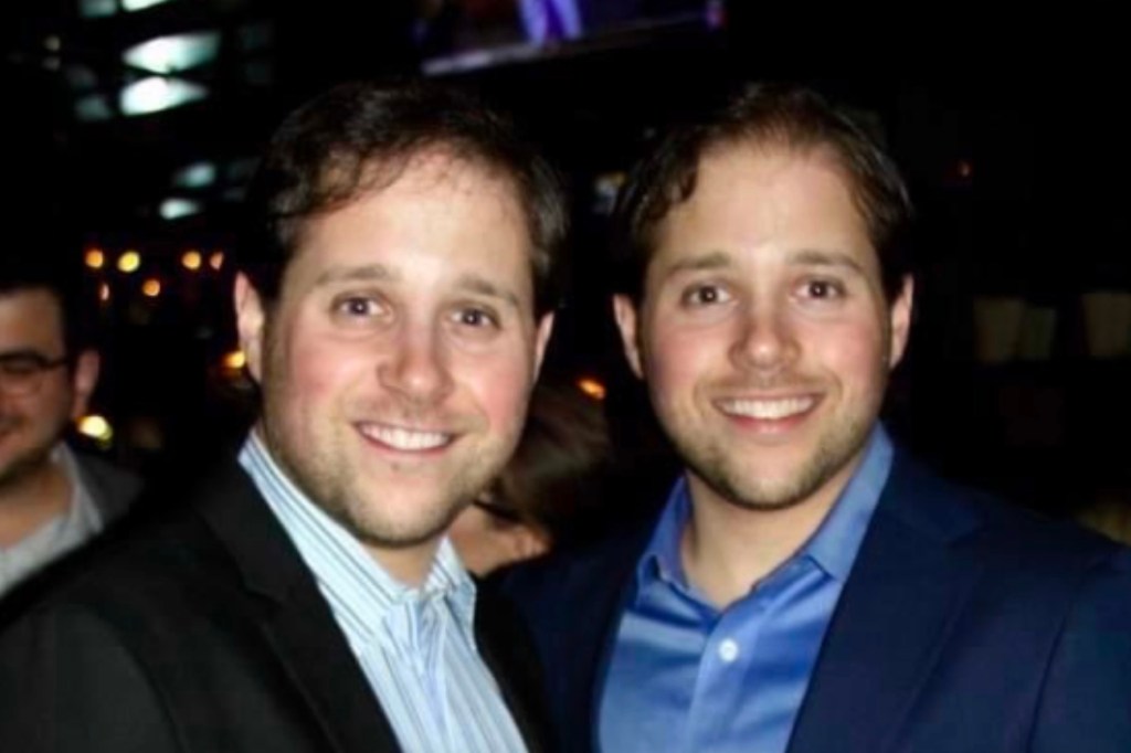 Twin brothers Adam and Daniel Kaplan smiling at the camera.