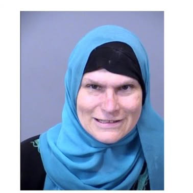 Mugshot of a protester wearing a blue headscarf.