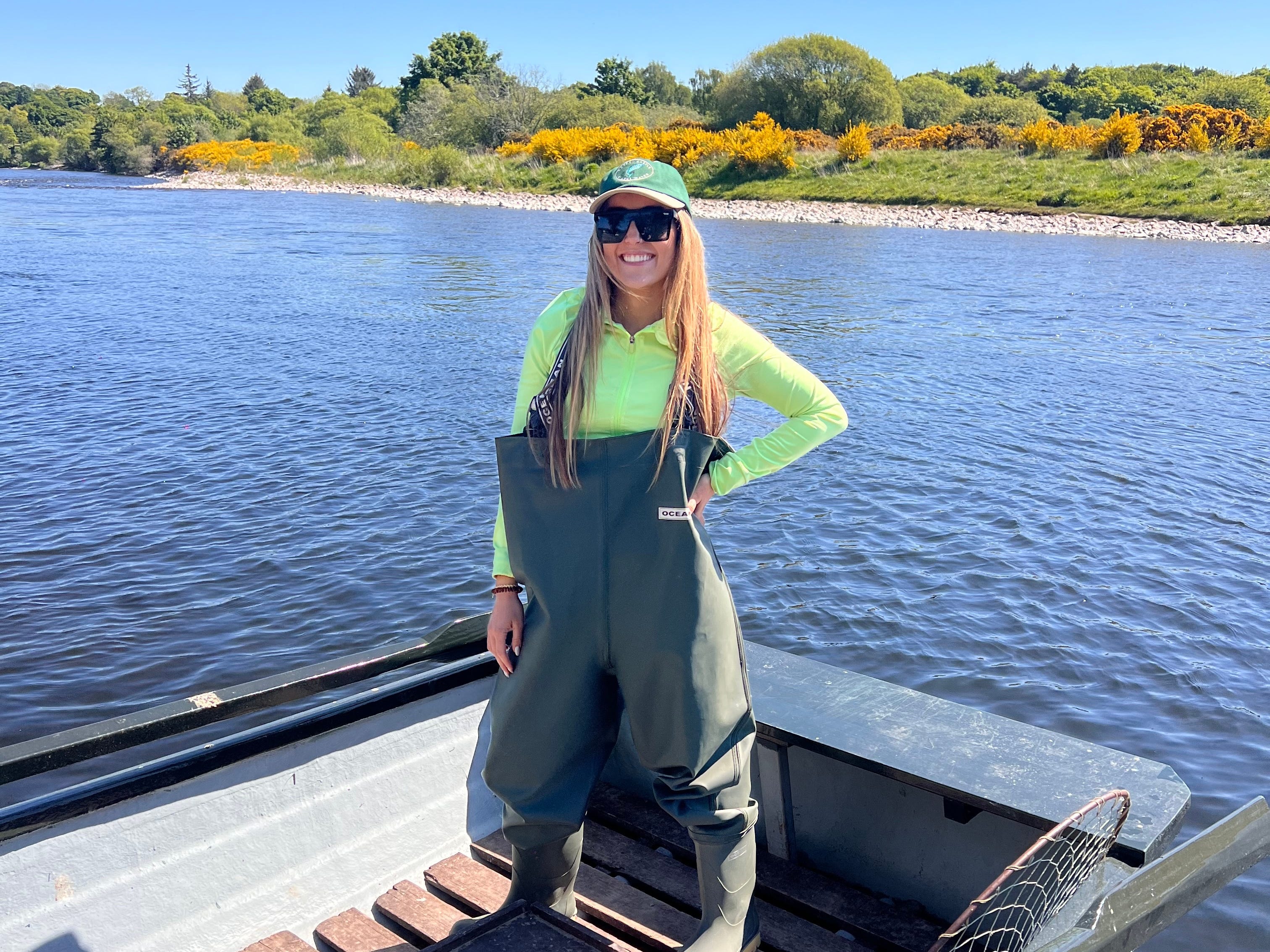 Gentry wearing fly-fishing gear in a boat on the River Spey.